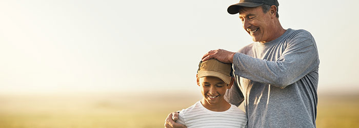 Father and son standing in a field.